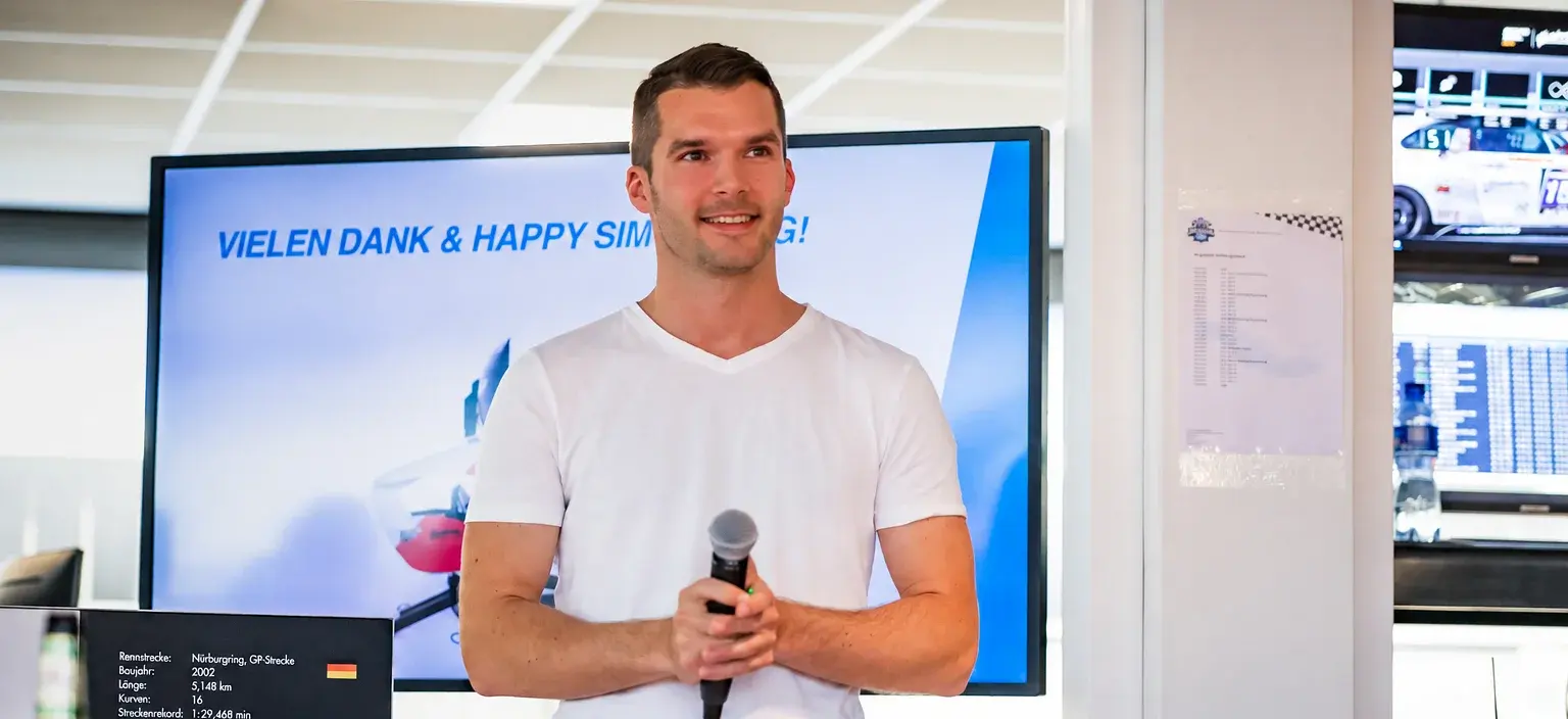 Yannick Mettler speaking with a microphone in front of a presentation screen